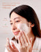 A woman applying Beautederm La Fraise Gommage Instant White Polish on her face.